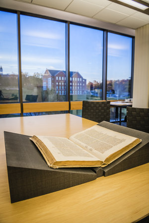 A book sitting open on a foam book rest in the Archives Reading Room