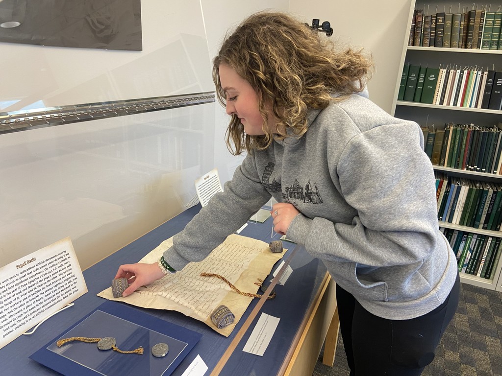 Rylee Miller arranging an archival exhibit case in LNDL's Archives and Special Collections reading room